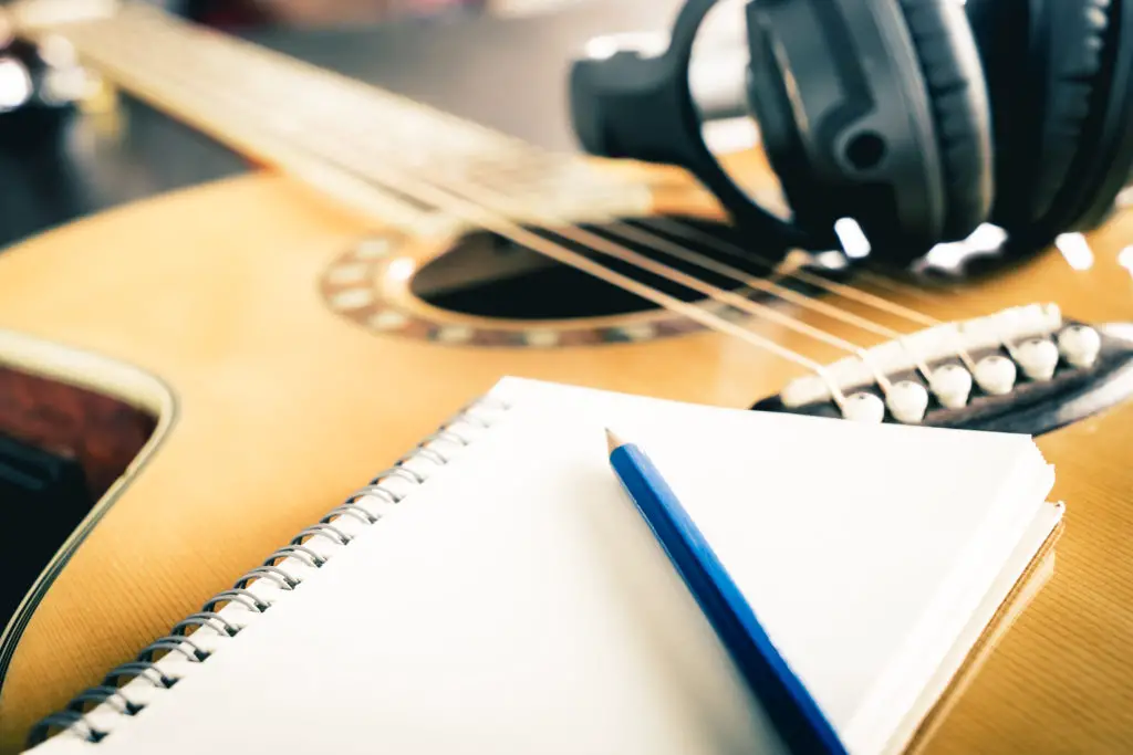 Guitar and Headphone with blank notebook for songwriting
